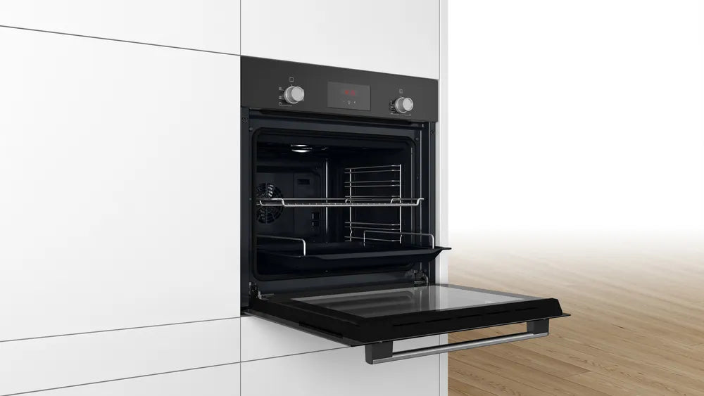 Bosch HHF113BA0B Built-in Single Oven with fitted 13Amp Plug in Black from HomeWise Appliances stock photo showing oven in a kitchen cabinet with the door open.