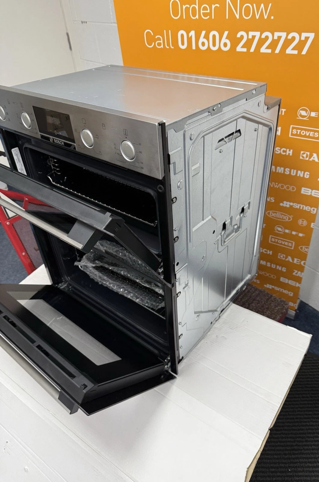 Bosch Series 4 NBS533BS0B Electric Built-Under Electric Double Oven in Stainless Steel from HomeWise Appliances. Showroom photo showing the oven angled with doors open and the front and right side on display.